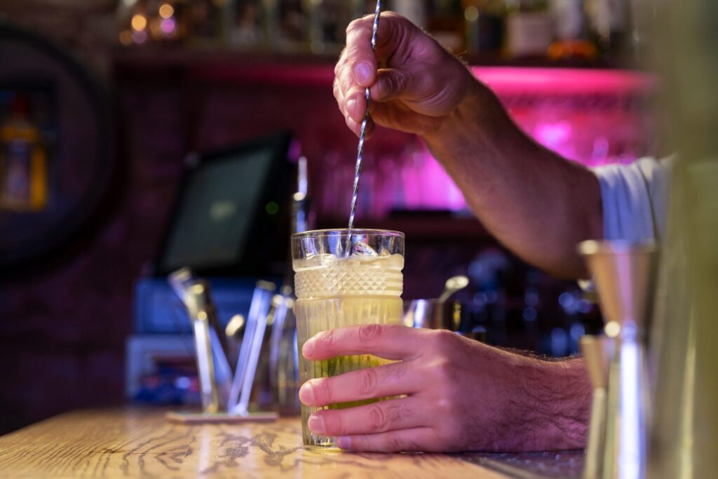 Pessoa mexendo drink -Como se planejar para expandir o seu bar